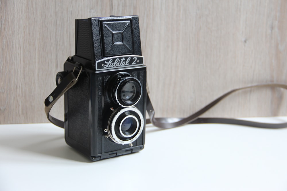 Fotocamera reflex digitale Nikon nera e argento su tavolo bianco