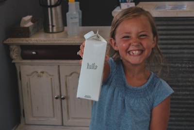 A smiling child holding a handmade thank you card.