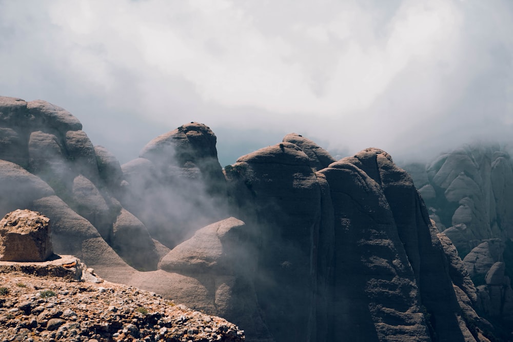 black rock formation under white clouds during daytime