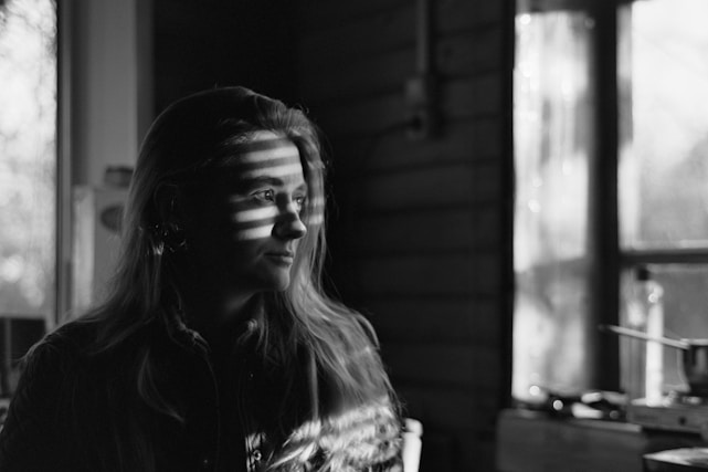 A serene woman contemplating her future in a sunlit room.