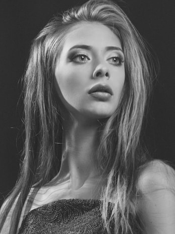 A softly lit portrait of a poised woman in elegant attire, exuding warmth and confidence.