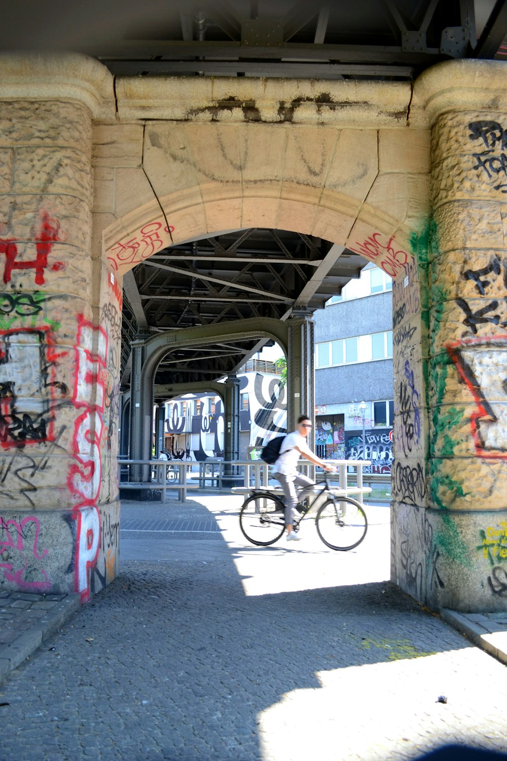 man in white shirt riding bicycle on road during daytime