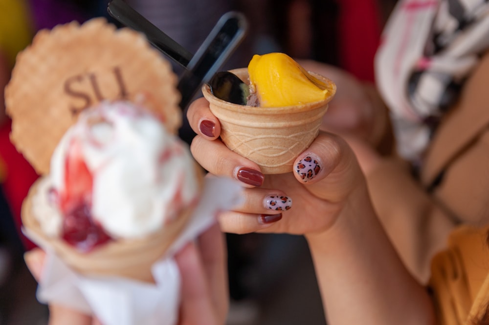 person holding ice cream cone with ice cream