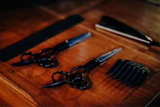black framed eyeglasses beside black pen