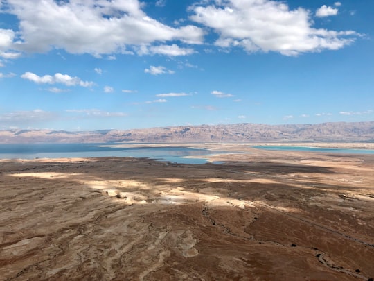 brown sand near body of water under blue sky during daytime in Masada Israel