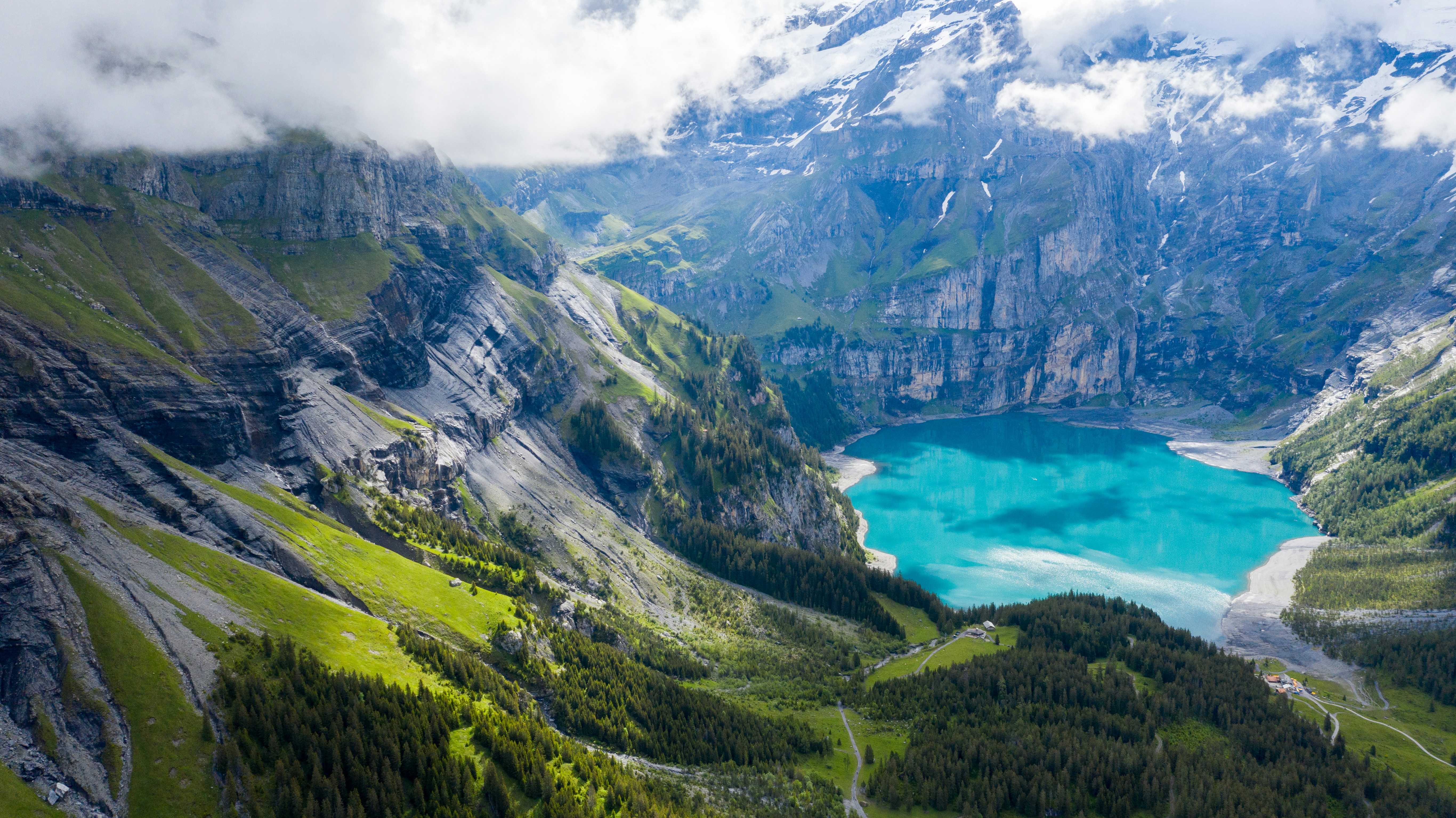 green and gray mountains near blue sea under white clouds during daytime