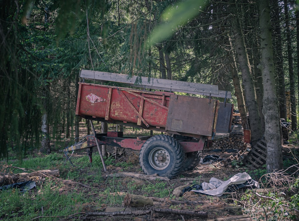 red and brown utility trailer in forest during daytime