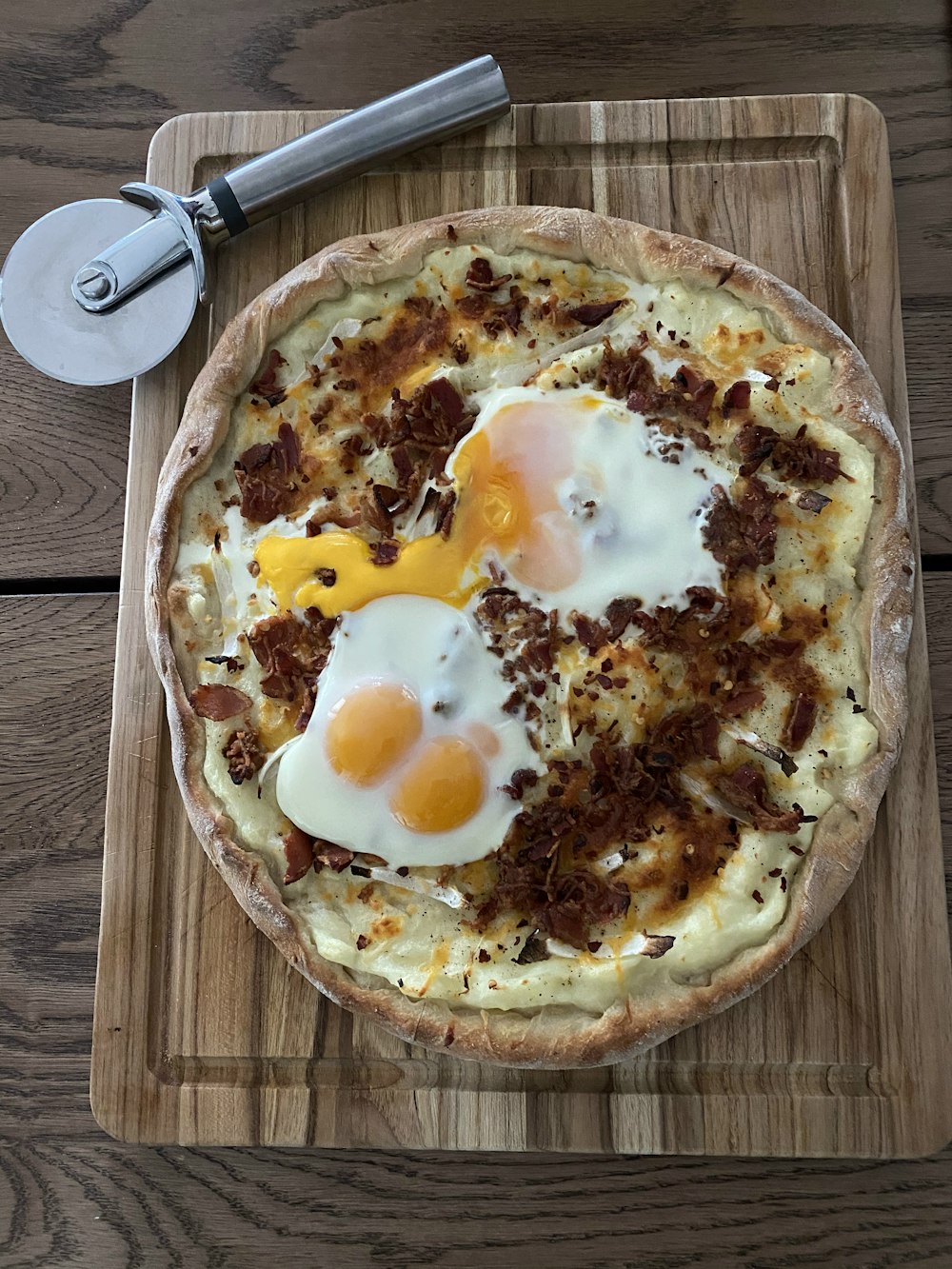 pizza with egg and cheese on brown wooden table