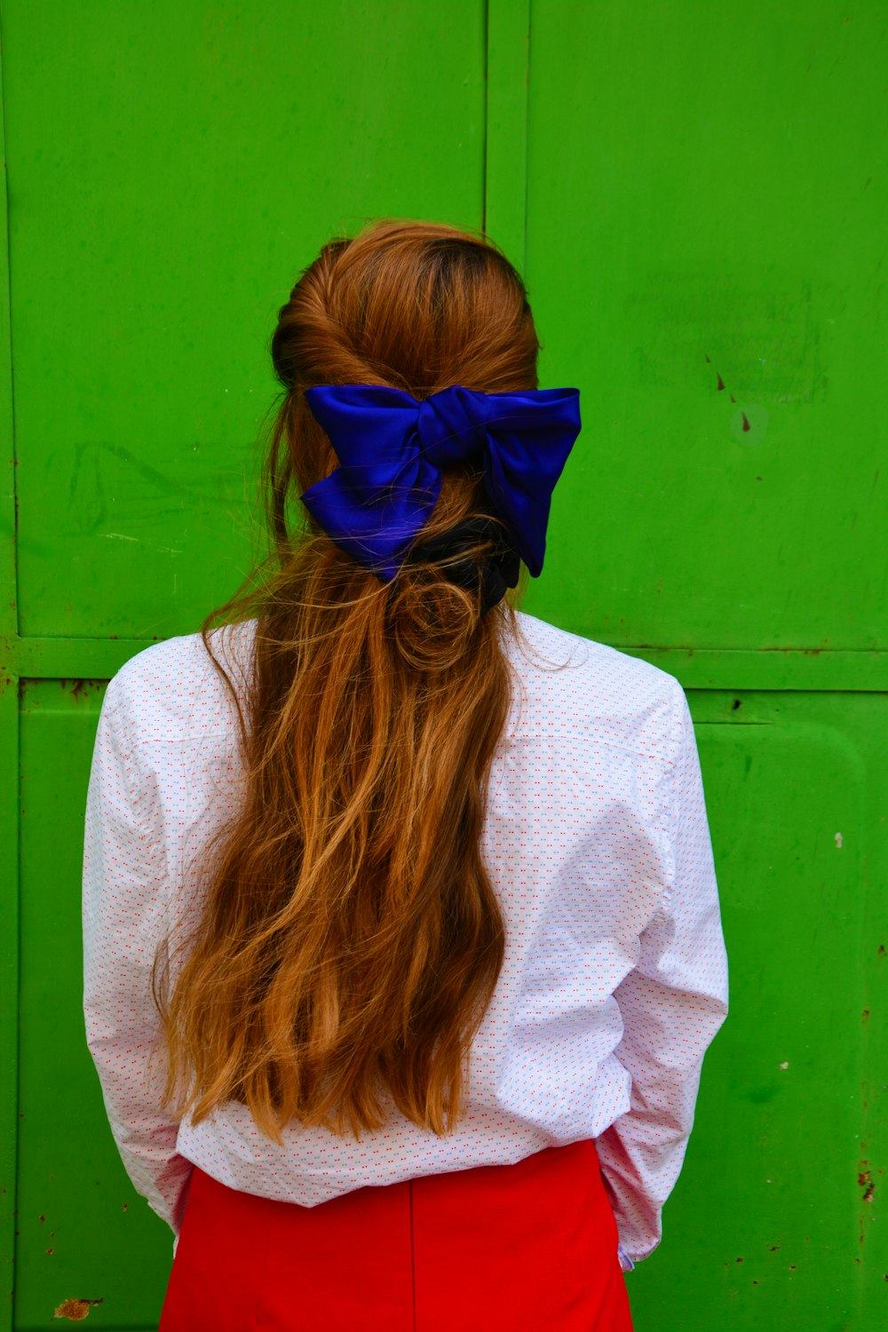 woman in white sweater wearing blue sunglasses