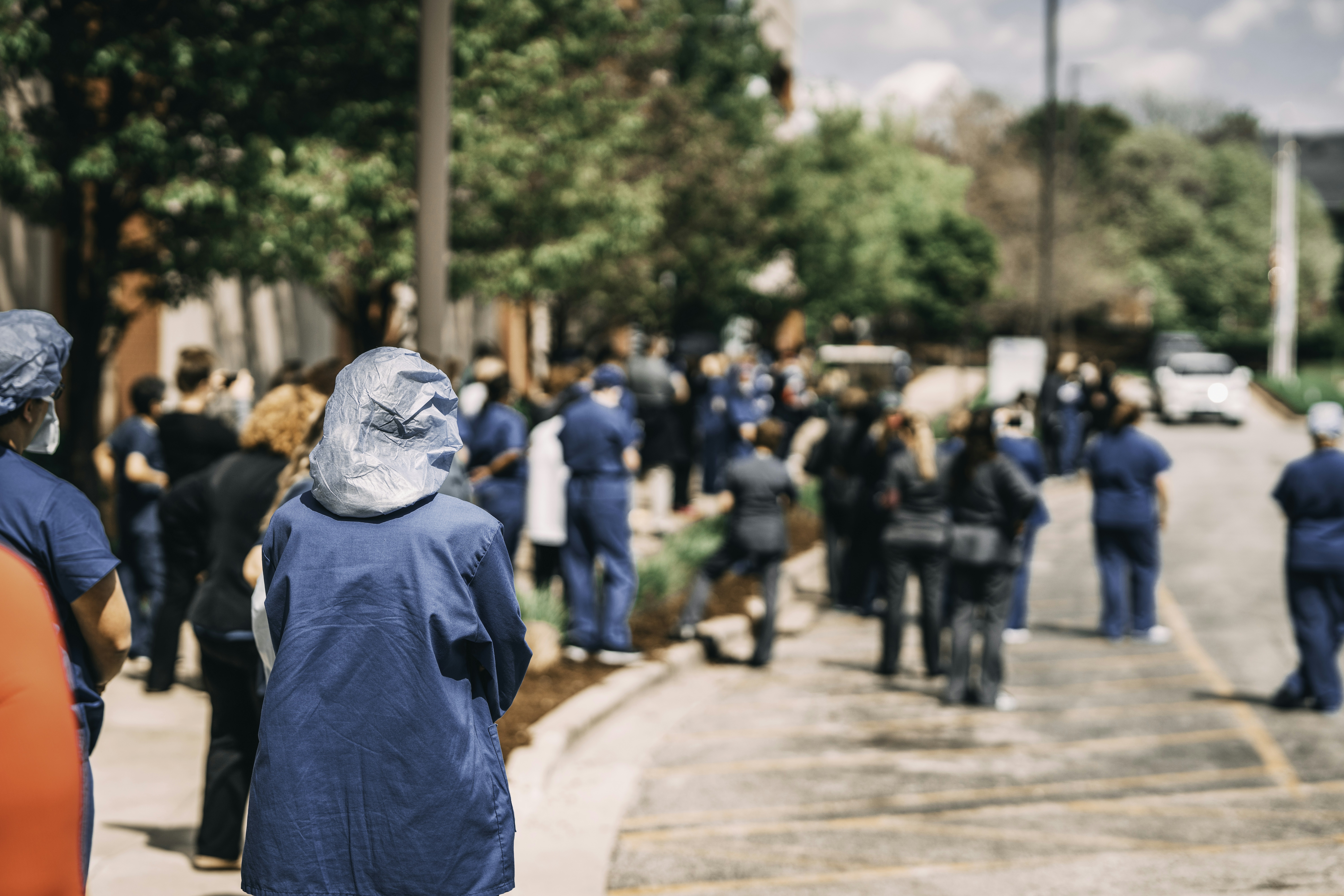 man in blue hoodie walking on street during daytime