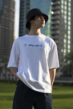 A minimalist streetwear outfit featuring a custom t-shirt against a backdrop of Stockholm’s urban skyline at dusk.