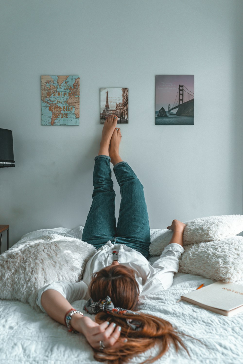 woman in blue denim jeans lying on bed