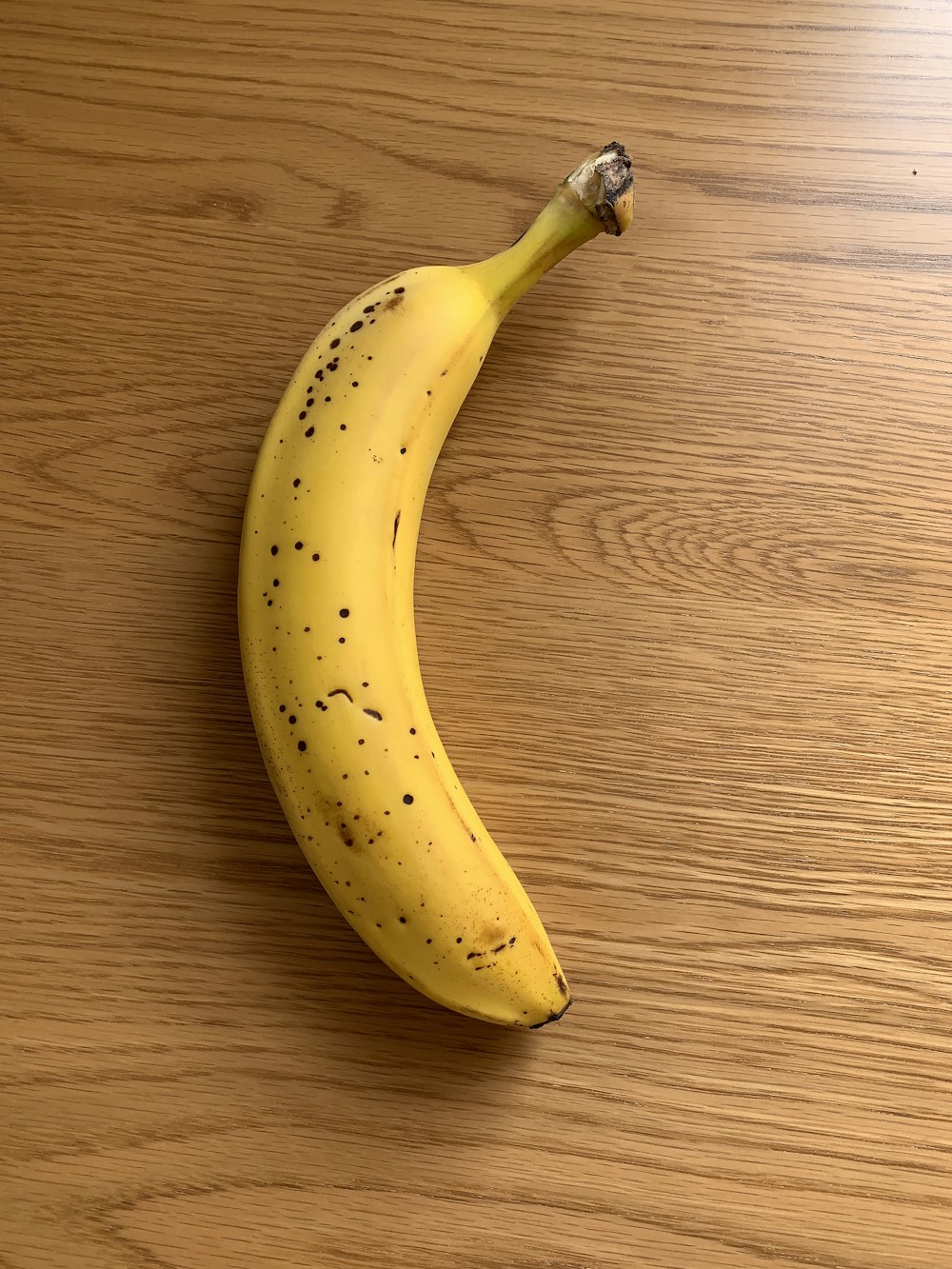 Fruta de plátano amarillo sobre mesa de madera marrón