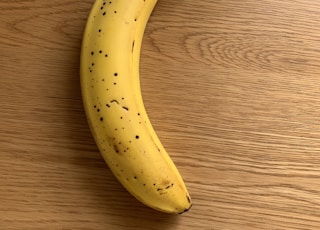 yellow banana fruit on brown wooden table