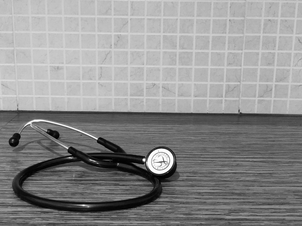 black and silver stethoscope on brown wooden table
