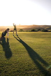 2 person walking on green grass field during daytime