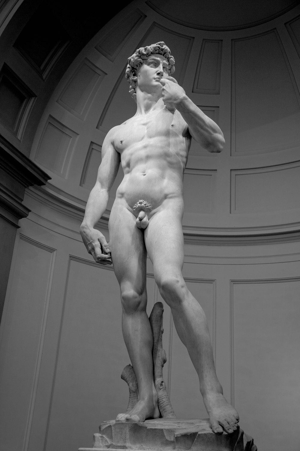 Estatua de hombre desnudo en fotografía en escala de grises