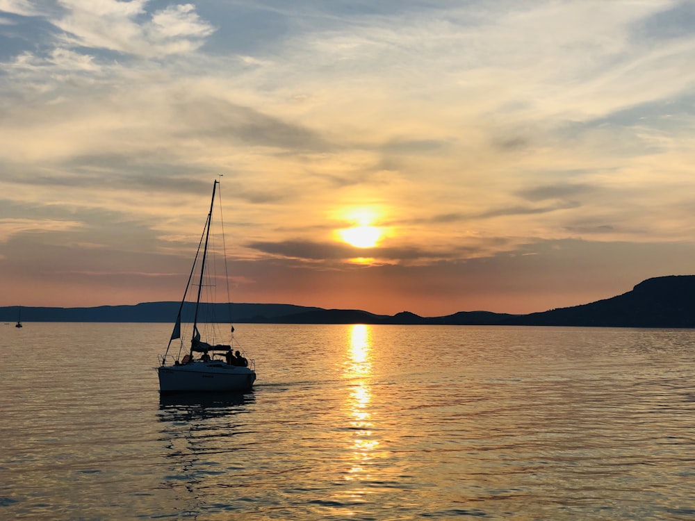 夕暮れ時の海上のボートのシルエット