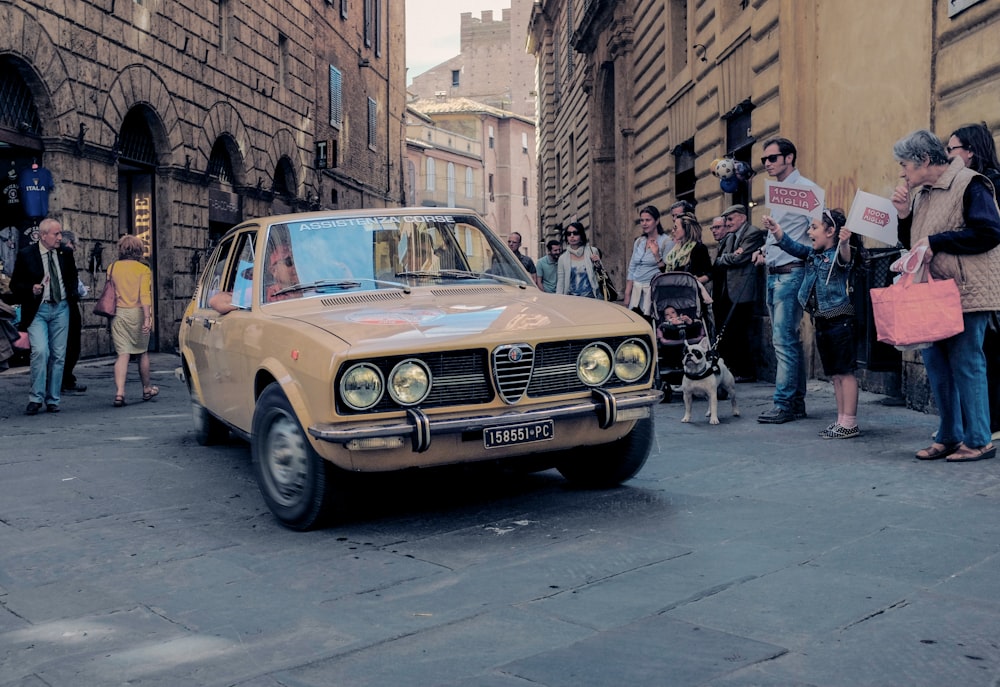 yellow mercedes benz car parked beside brown concrete building during daytime