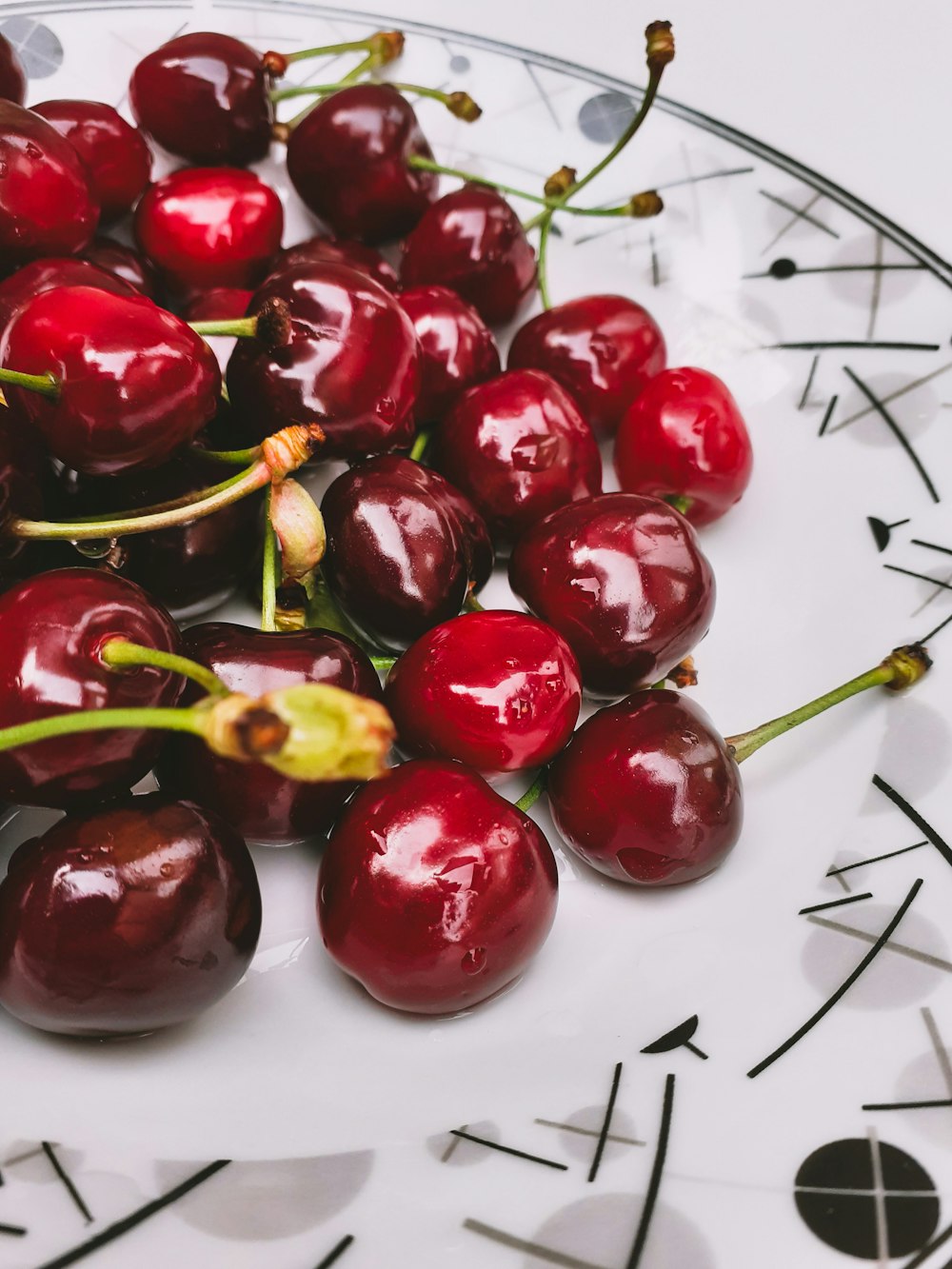 red cherries on white ceramic plate