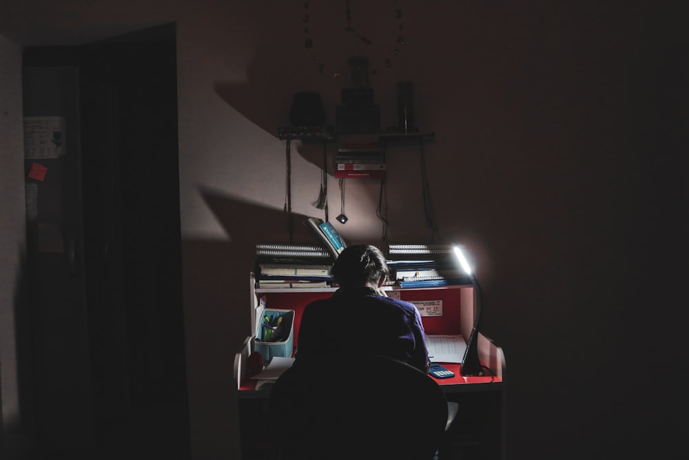 man in black shirt sitting on chair using computer