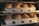 Baking trays filled with freshly baked loaves of bread inside an oven. The bread is golden brown and appears to be well-risen with crusty tops. The metal trays have multiple compartments, each holding one loaf of bread.