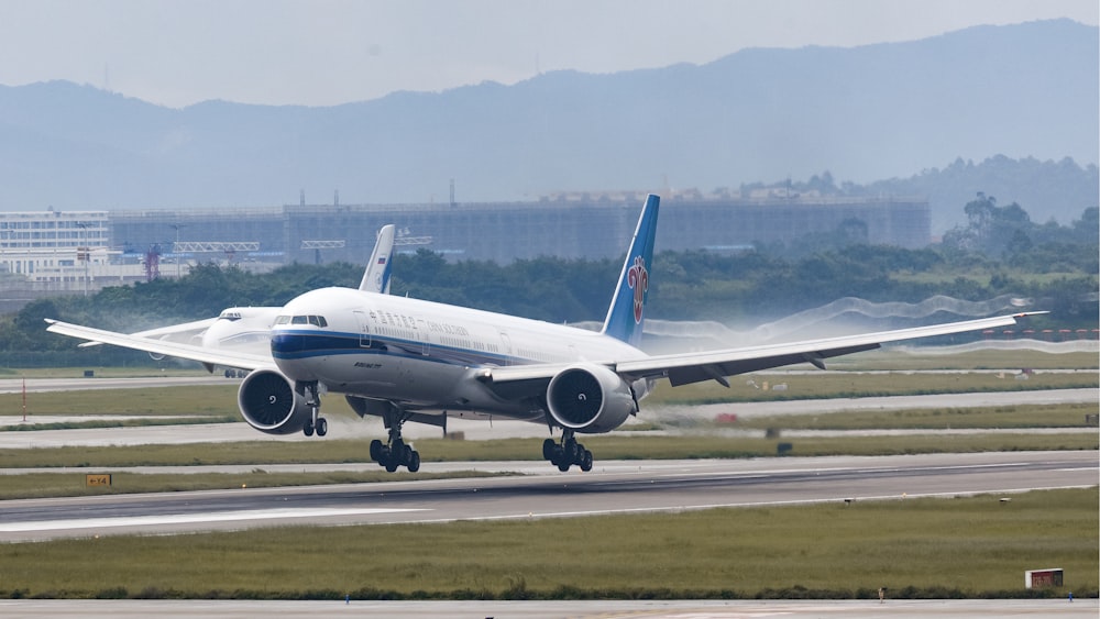 white and blue passenger plane on airport during daytime