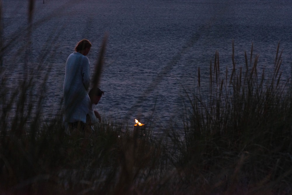 man in white shirt standing near body of water during daytime