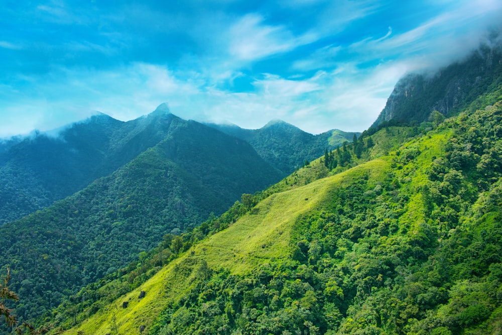 montanhas verdes sob o céu azul durante o dia