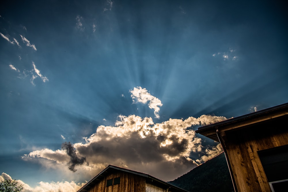 brown wooden house under blue sky and white clouds during daytime