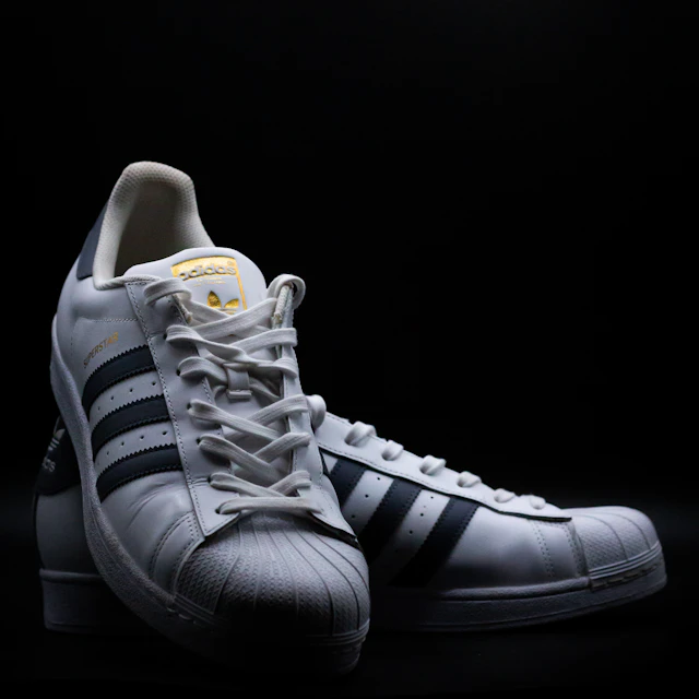 A black and white adidas Superstar sneaker shown in close up