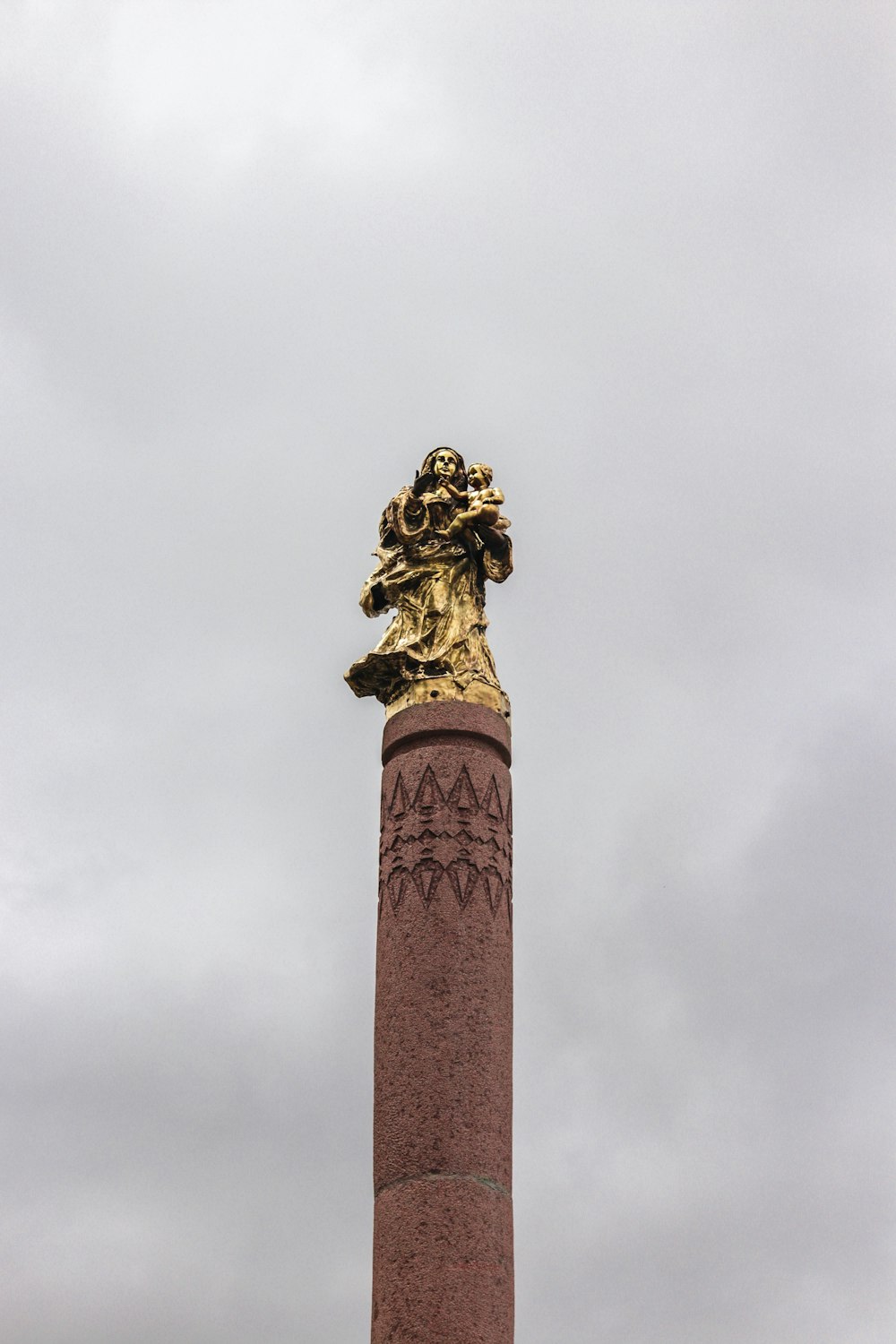 statua di cemento marrone sotto nuvole bianche durante il giorno