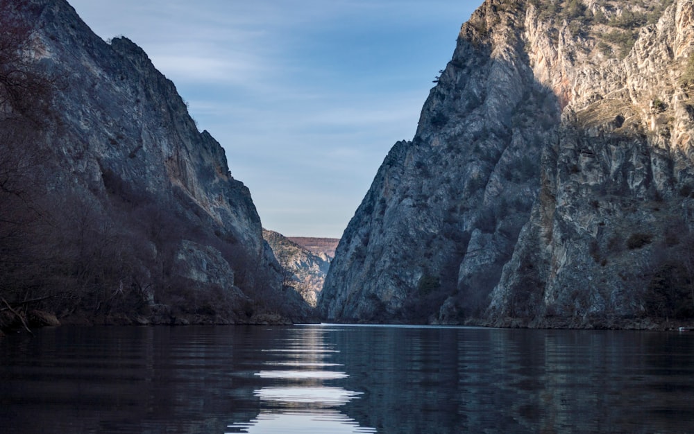 Montaña rocosa marrón junto al cuerpo de agua durante el día