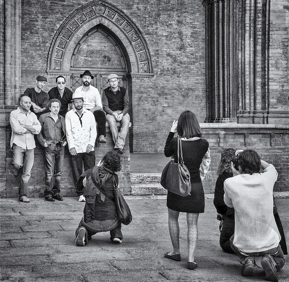 Foto in scala di grigi di persone che camminano per strada