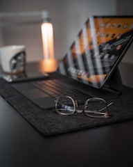 black framed eyeglasses on macbook pro