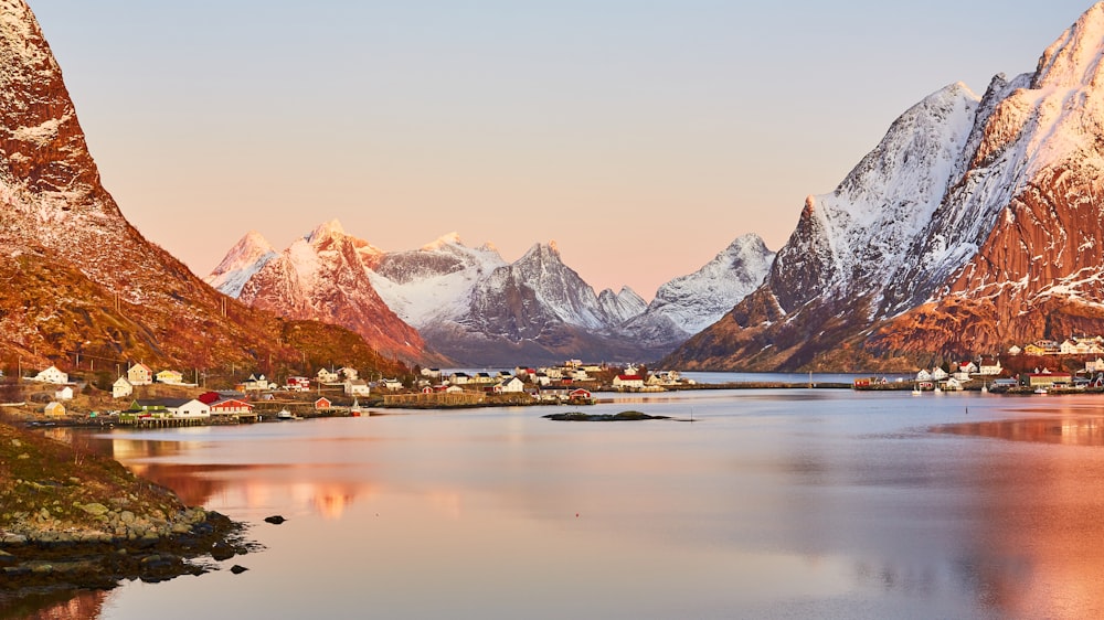 snow covered mountain near lake during daytime