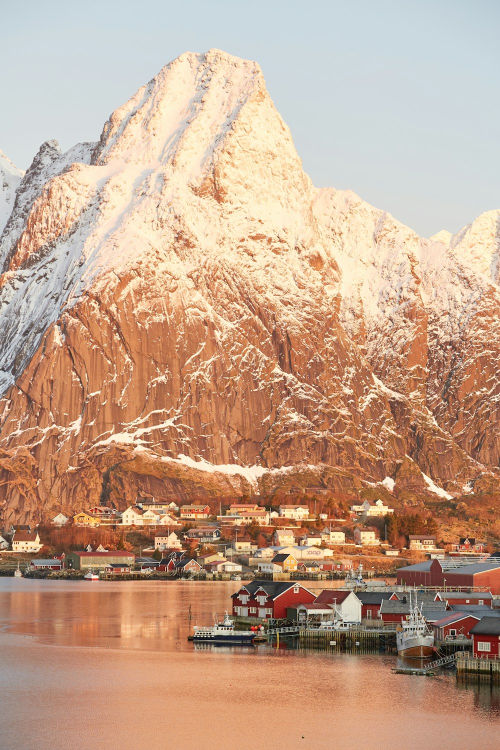 brown and white mountain near body of water during daytime