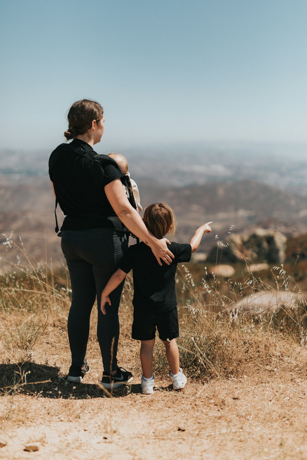 man in black t-shirt and black shorts holding woman in black t-shirt