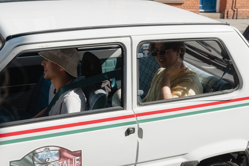 man in blue and white plaid button up shirt driving white and green car during daytime