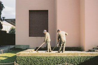 man in white long sleeve shirt and gray pants standing on green grass field