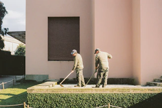 man in white long sleeve shirt and gray pants standing on green grass field