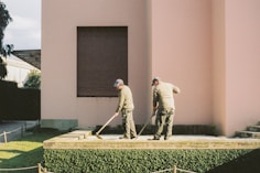 man in white long sleeve shirt and gray pants standing on green grass field
