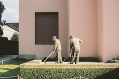 man in white long sleeve shirt and gray pants standing on green grass field