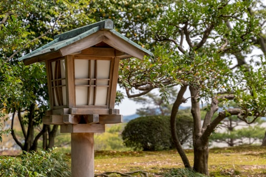 brown wooden bird house on green grass field during daytime in Kenroku-en Japan