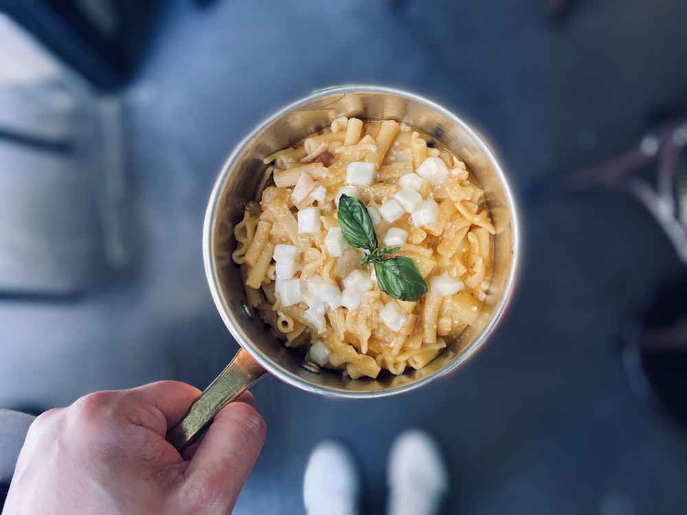 Person, die Edelstahllöffel mit Essen hält