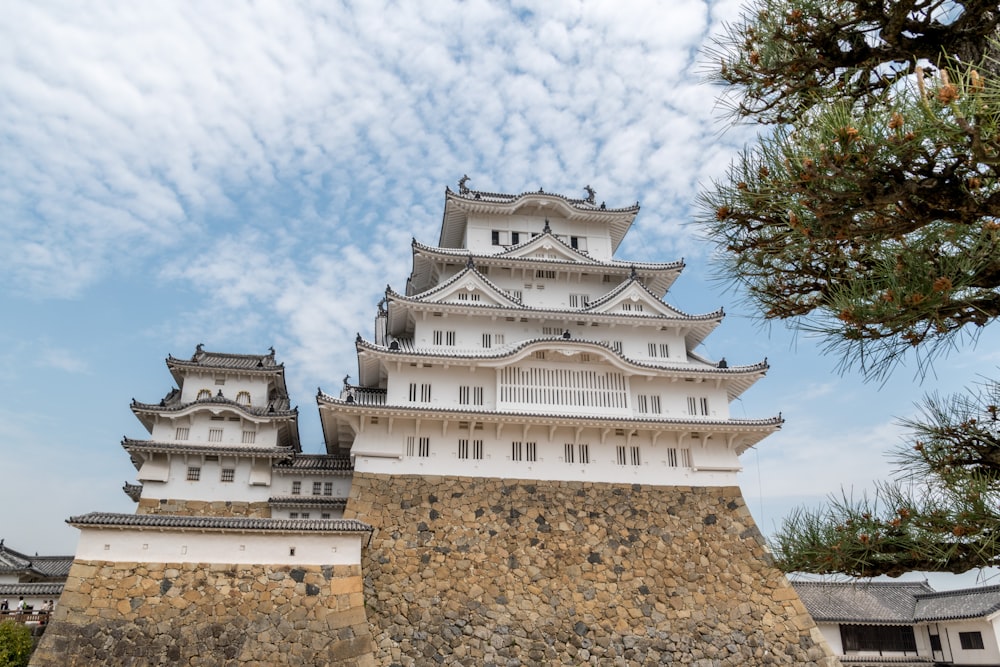 昼間の白い雲の下の白と茶色のコンクリートの建物