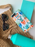 black framed sunglasses beside blue and white floral iphone case