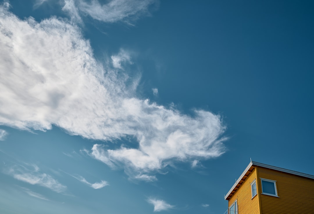 brown concrete building under blue sky and white clouds during daytime