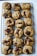A batch of freshly baked chocolate chip cookies is cooling on a black wire rack. The cookies are golden brown with large, molten chocolate chunks visible on top, giving them a homemade and inviting appearance.