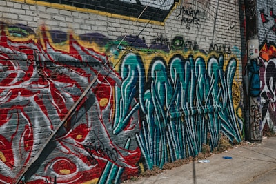 Colorful street art on an old brick wall in a lively urban neighborhood.